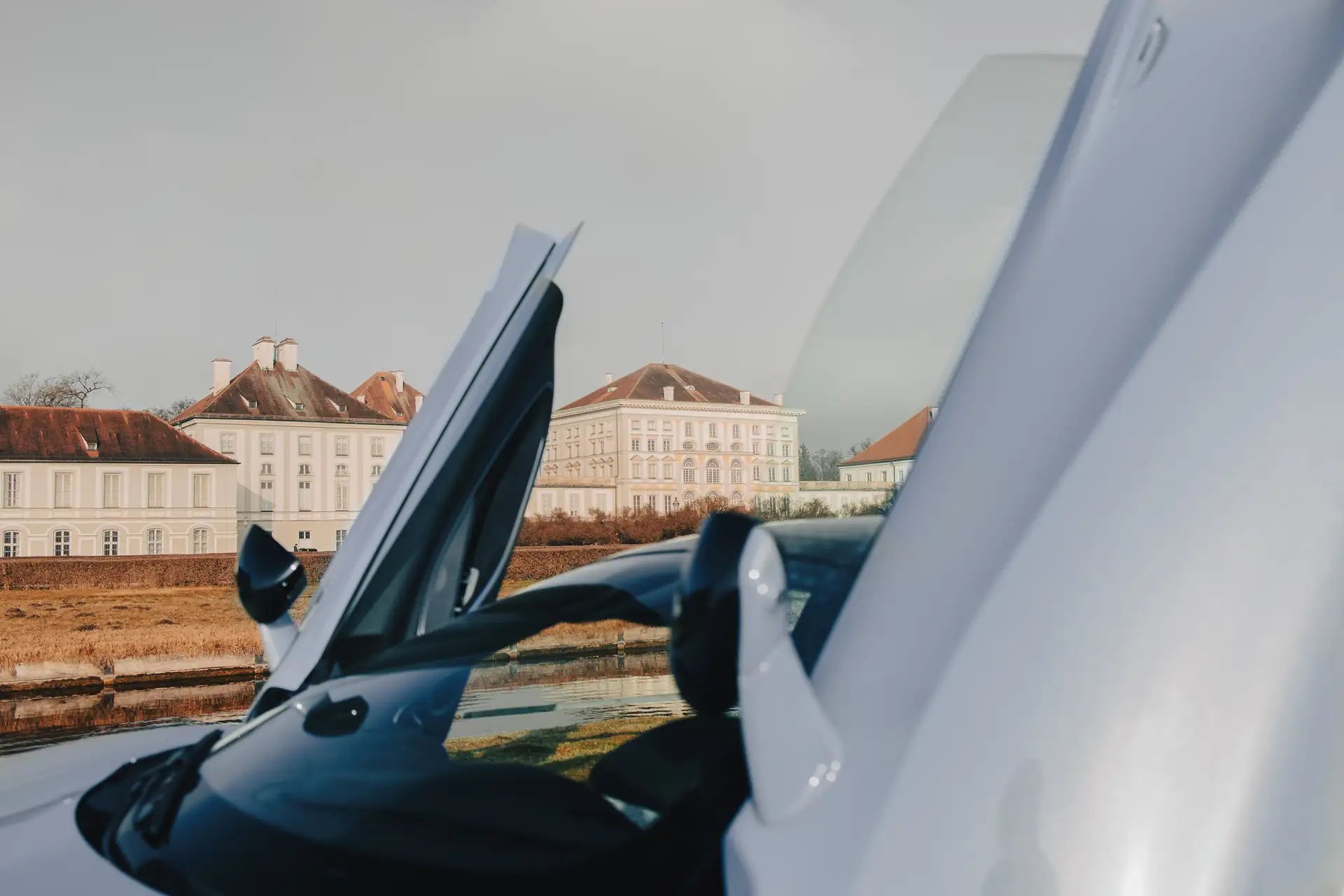 Detailaufnahme von dem McLaren Atura Spider mit geöffneten Flügeltüren vor einem historischen Schlossgebäude